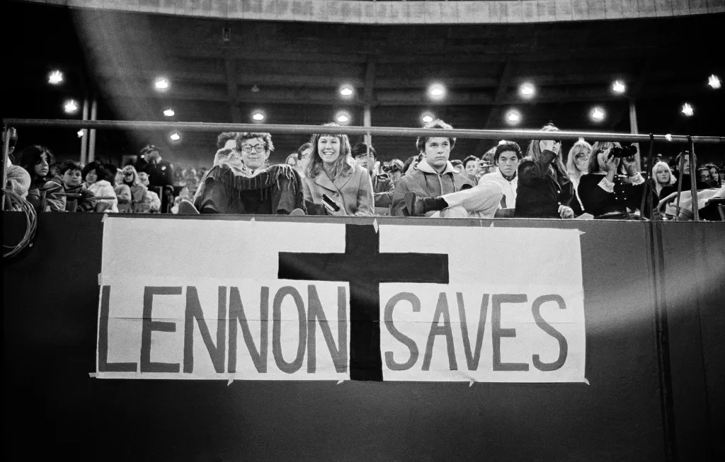 A photo of the audience at Candlestick Park, and a poignant sign following Lennon's controversial comment about the Beatles being more popular than Jesus.
